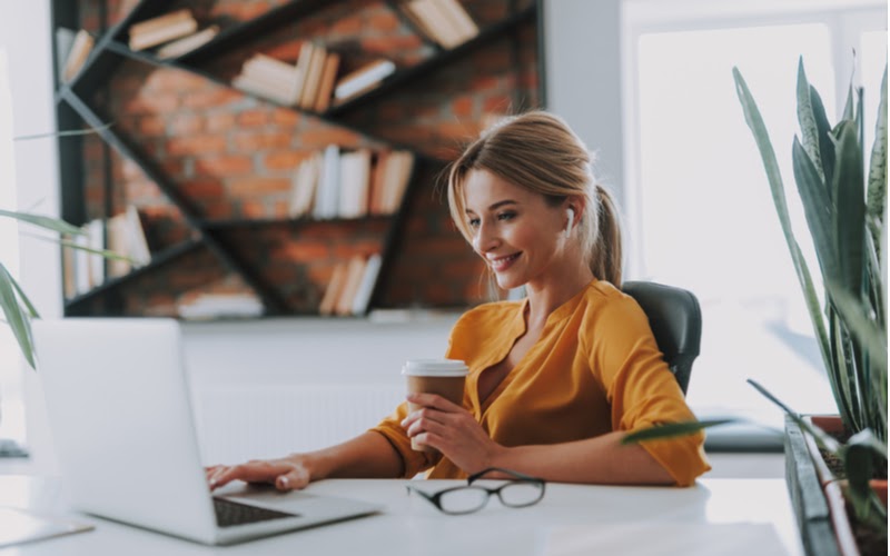how esign genie offers secure digital signature Woman drinking coffee and using a laptop